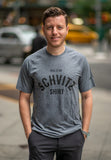 A man in NYC wearing a grey workout T-shirt that says "This is my SCHVITZ shirt"