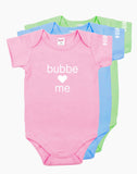 Pink, Blue and Green onesies that say "bubbe loves me" in white letters on the front. There is a heart instead of the word love.