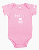 Pink onesie that says "bubbe loves me" in white letters on the front. There is a heart instead of the word love.