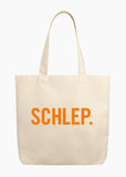 A beige tote bag with the word "SCHLEP." written on the front in orange letters.