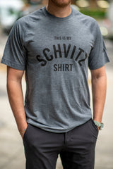 A man in NYC wearing a grey workout T-shirt that says "This is my SCHVITZ Shirt"