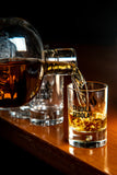 Tequila Sedola being poured into a glass on a wooden surface.