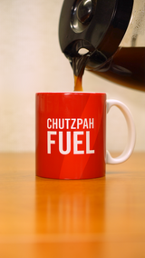 A coffee pot pouring coffee into a red mug that says "Chutzpah Fuel" in white letters. 