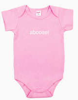Pink baby onesie with the word ‘aboose!’ printed in white.