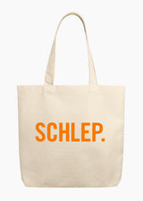 A beige tote bag with the word "SCHLEP." written on the front in orange letters. 
